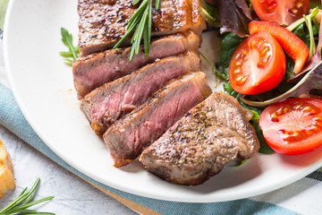 Grilled beef striploin steak with fresh salad.