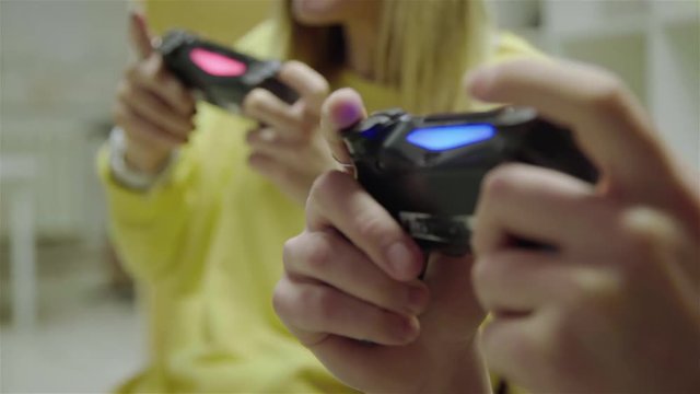 Close up, friends playing video game using wireless controller