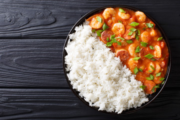 Delicious gumbo with prawns, sausage and rice on a plate. Horizontal top view