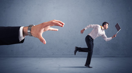 Businessman running from hand