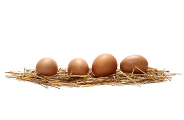 Eggs in straw nest isolated on white background