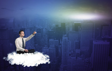 Fototapeta premium Man sitting on a cloud above the city