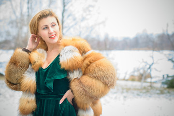 Young lady in fox fur jacket and velvet dress, vintage elegant style in everyday life, retro 50h lifestyle for women. Pretty woman outdoor on a balcony at nature view 