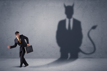 Fototapeta premium Biznes człowiek patrząc na własną koncepcję cienia demona diabła