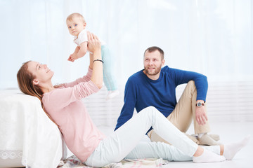 Parenting family. Mother and father playing with little newborn baby