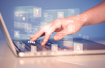 Hand typing on keyboard with digital tech icons