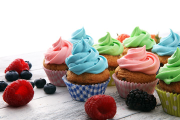 Tasty cupcakes on wooden background. Birthday cupcake in rainbow colors