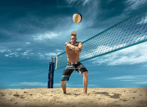 Beach volleyball player in action at sunny day under blue sky.