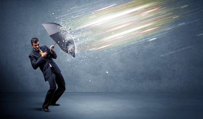 Business man defending light beams with umbrella concept