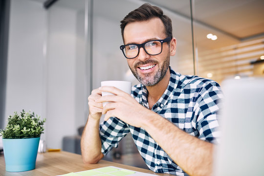 Designer taking break drinking coffee, working from home office