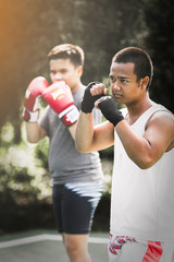 Plakat Asian young men with personal trainer boxing friend, Boxing gloves