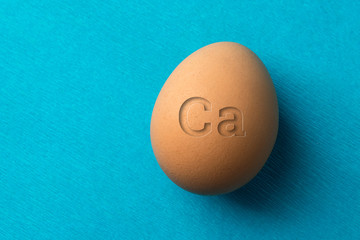 A red, chicken egg on a blue background, the eggs contain a lot of calcium for strengthening teeth and bones.