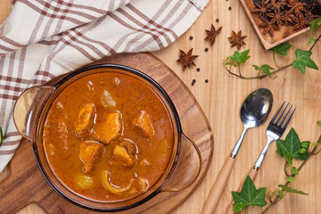 Chicken curry with spice on wooden background
