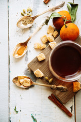 mulled wine in a mug and ingredients for making a drink on a white wooden background, top view