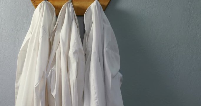 Laboratory coats hanging on hook 
