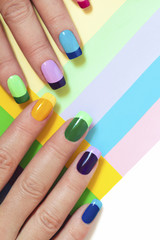 Multi-colored pastel manicure combined tone on tone with a striped background.Nail art.