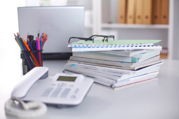Office table with blank notepad and laptop
