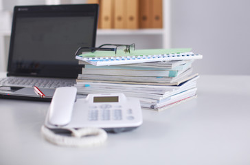 Office table with blank notepad and laptop