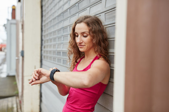 Sportlicher Teenager blickt auf Smartwatch