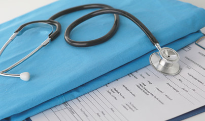 Stethoscope on a table with medical uniform