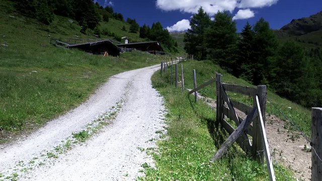 Feldweg in den Bergen am Weidezaun