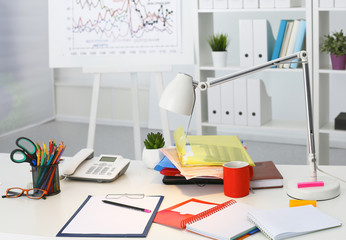 Office table with blank notepad and laptop