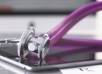 healthcare and technology concept - tablet pc, stethoscope and tablet on the table