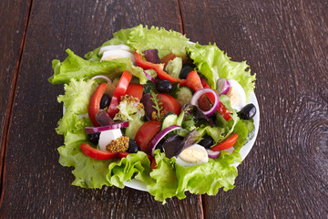salad from fresh vegetables in a plate on a table, selective focus