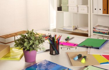 Office table with blank notepad and laptop