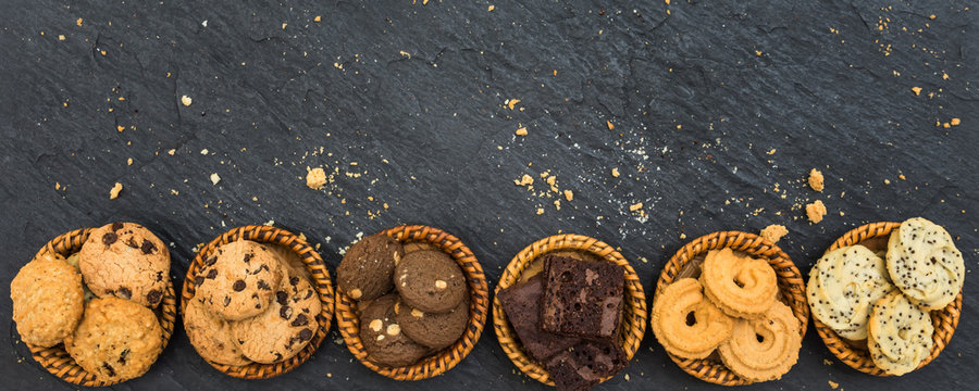 Top view different cookies on table top, Flat lay of various cookies on black stone for background, Prepared cookies food buffet on table for serve