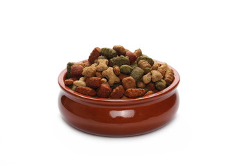Dry colorful dog food in red porcelain bowl isolated on white background