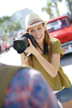 Woman photographer taking picture of model in the street of Miami