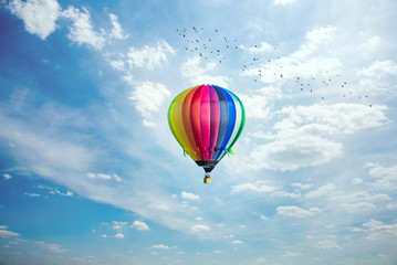 Fototapeta premium Colorful hot-air balloon riding across blue sky