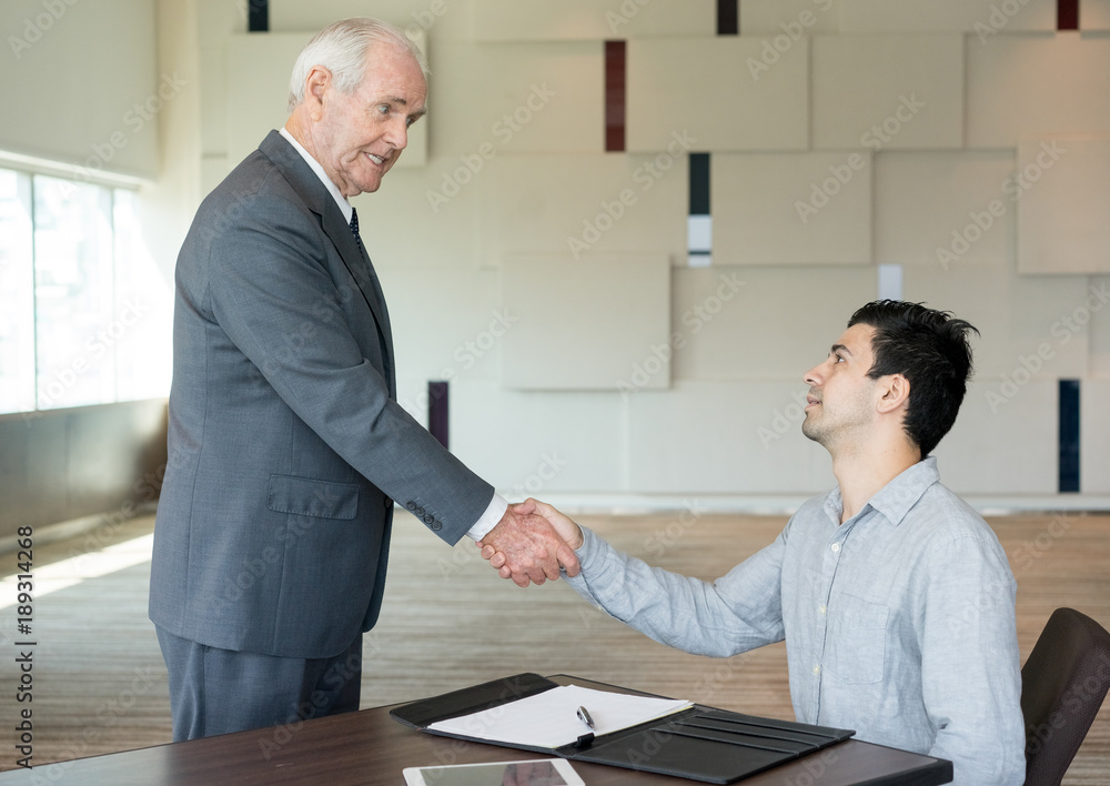 Wall mural Young managing director talking to senior employee