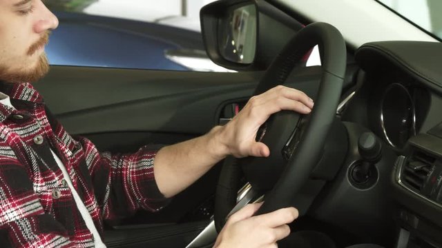 Cropped shot of a bearded man sitting in a car holding the steering wheel