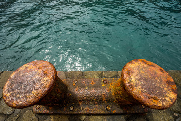 Draufsicht auf verrostete Schiffspoller in einem Hafen