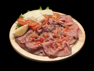 roastbeef with tomatoes on a wood dish