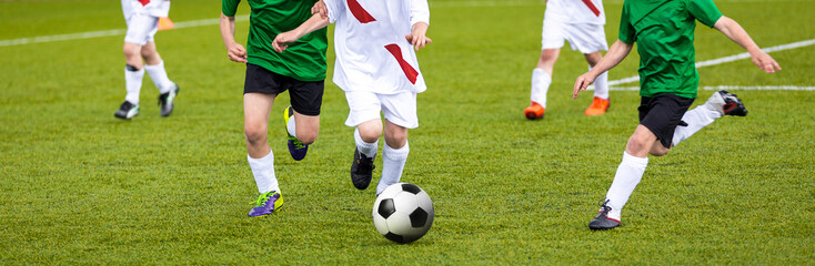 Football match for young players. Training and football soccer tournament for children. Youth soccer competition betweeen two footballers. Red team versus blue team