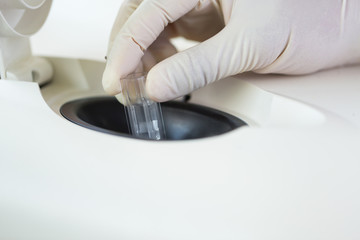 Scientist putting small tube to machine in laboratory