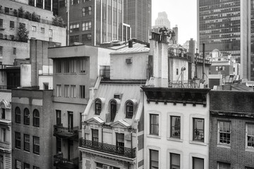 Black and white picture of old buildings in Midtown Manhattan on a rainy day, New York, USA.
