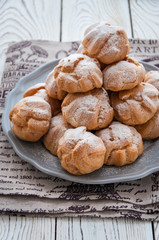 On the table there is a plate of profiteroles, a sweet dessert for breakfast