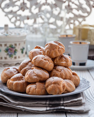 On the table there is a plate of profiteroles, a sweet dessert for breakfast