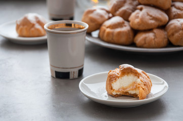 On the table there is a plate of profiteroles, a sweet dessert for breakfast
