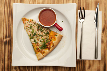 a piece of pizza Apolonia on a plate served with ketchup