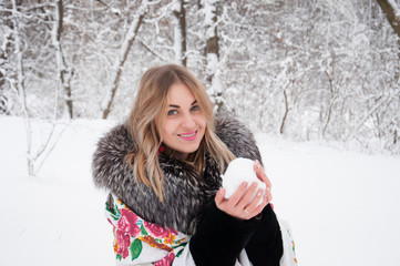 A happy woman walks through the winter forest, plays with snowballs, laughs and enjoys life.