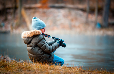 Boy using digital camera taking photo in the nature, hobby concept