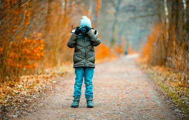 Boy using digital camera taking photo in the nature, hobby concept