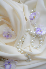 pearl beads on a delicate background with flowers violets, wedding gift