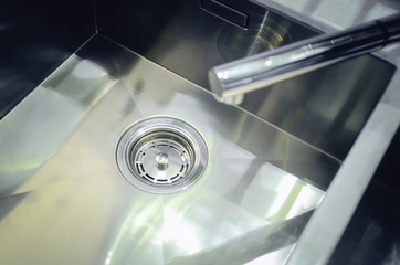New kitchen sink made of stainless metal. The concept of modern kitchen interior.