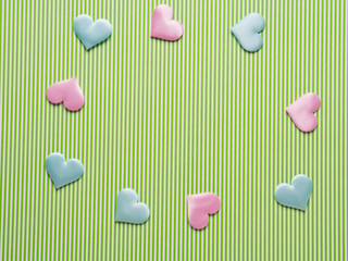 Green striped paper background with pastel color hearts frame. Valentine's mother day concept